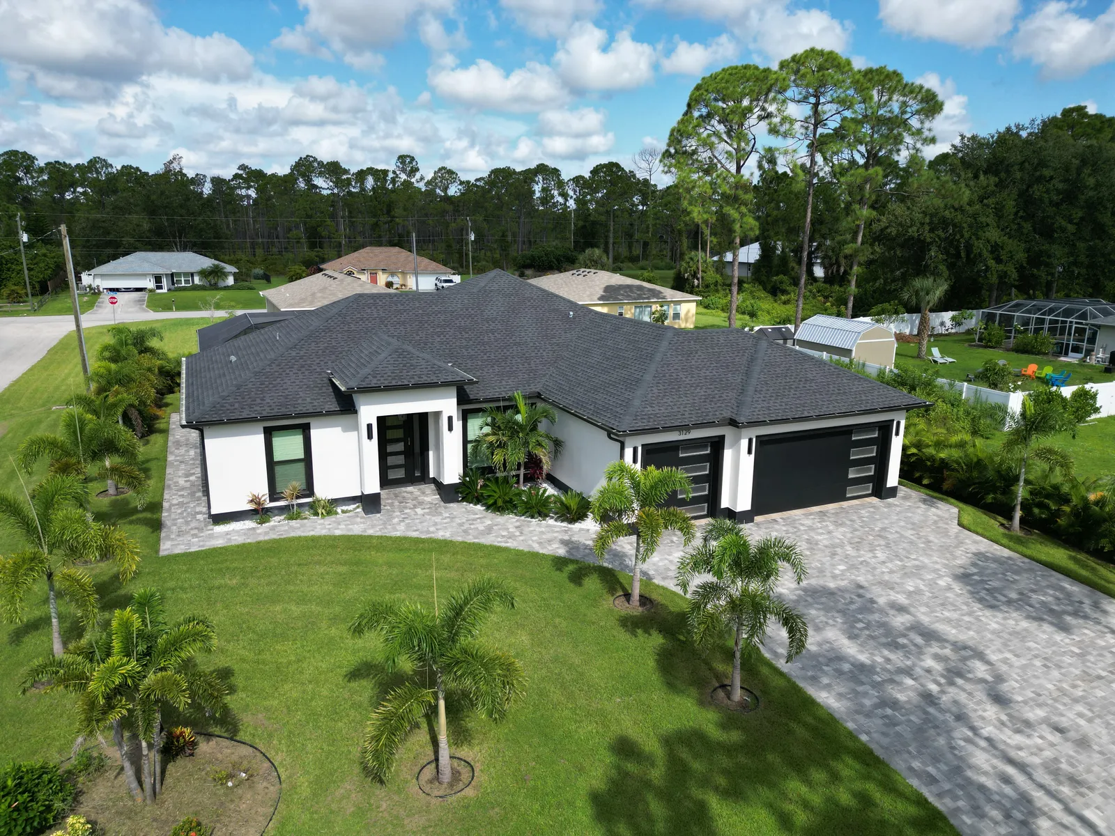 Aerial view of a custom home with palm-lined lawn, SW Florida