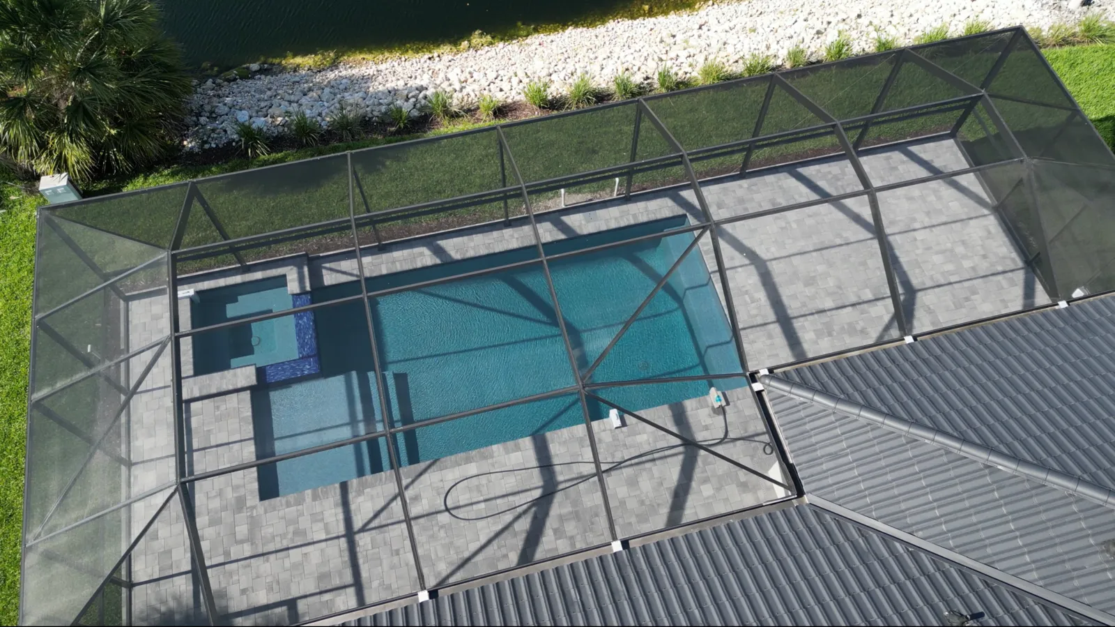Aerial view of a waterfront custom home with pool